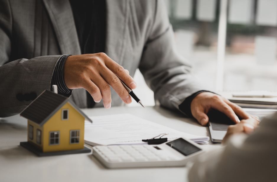 Persona con traje apuntando con un bolígrafo a un papeleo