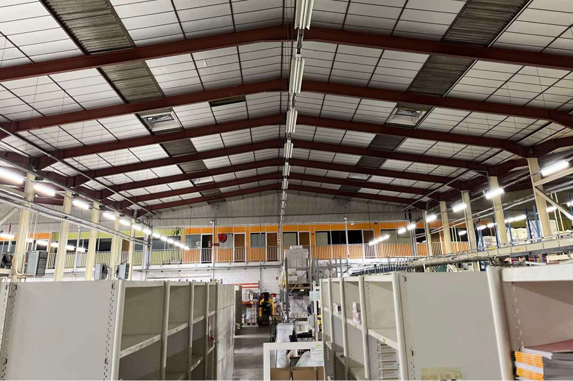 Un grand entrepôt avec beaucoup d'étagères et un plafond.