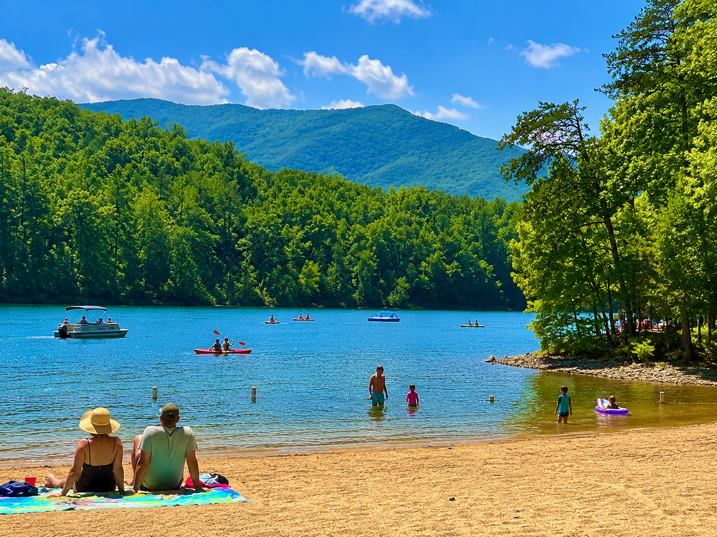 Sunny lake beach with swimmers, sandy shore, blue water, and green mountains under a clear sky