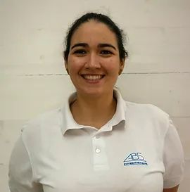 Une femme porte un polo blanc et sourit.