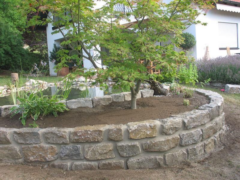 Muret en pierre en extérieur pour créer un massif fleuri