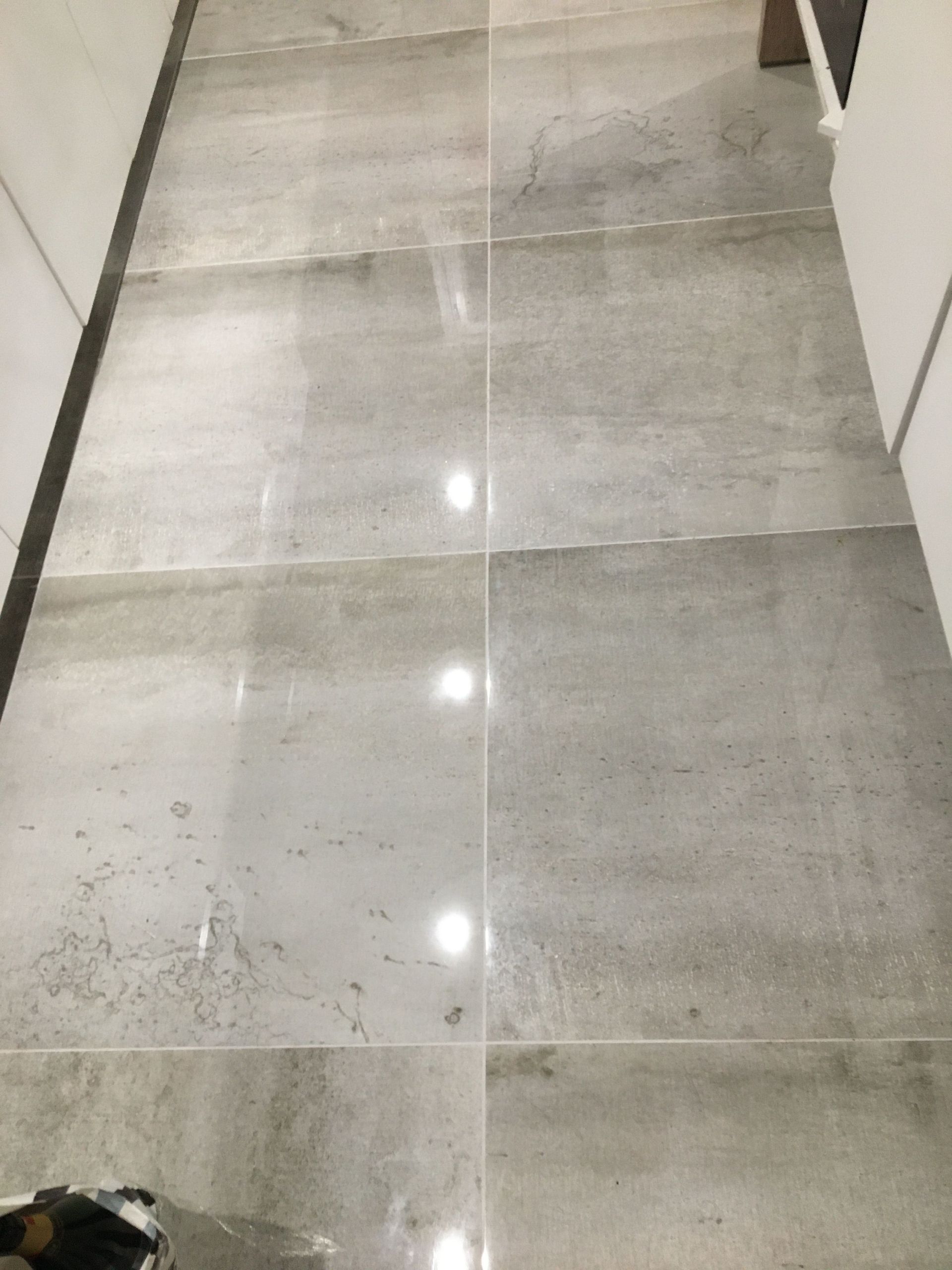 Pose de grands carreaux de carrelage dans un couloir