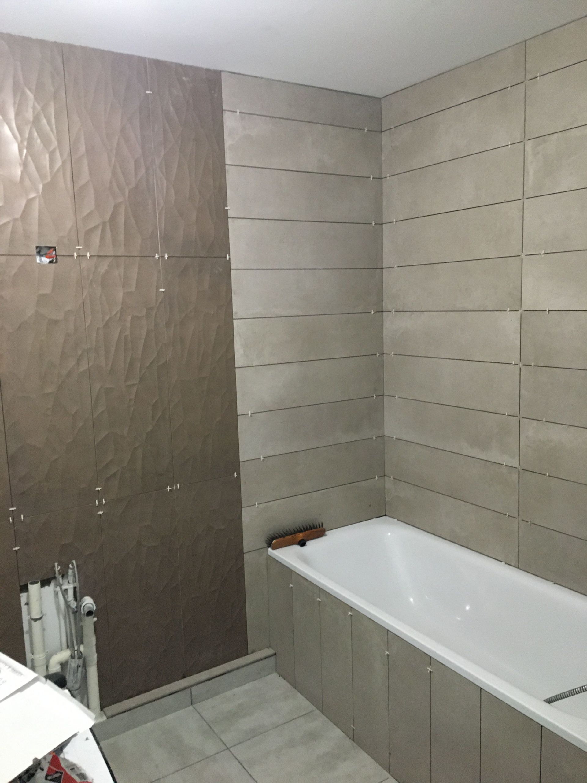 Pose de dalle de carrelage mural dans une salle de bains