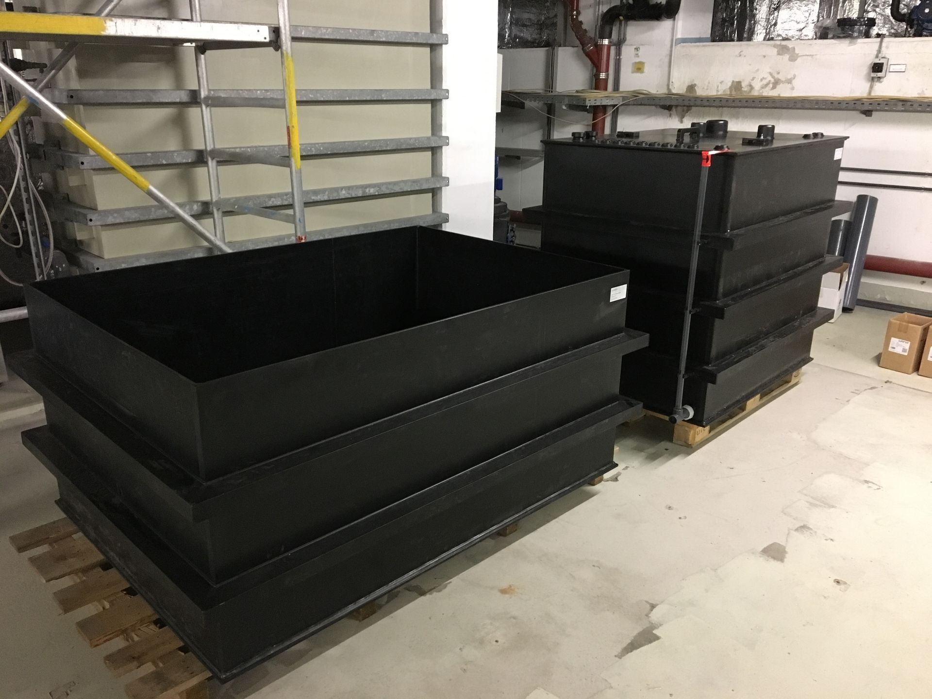 In einem Raum sind zwei große schwarze Tanks übereinander gestapelt.