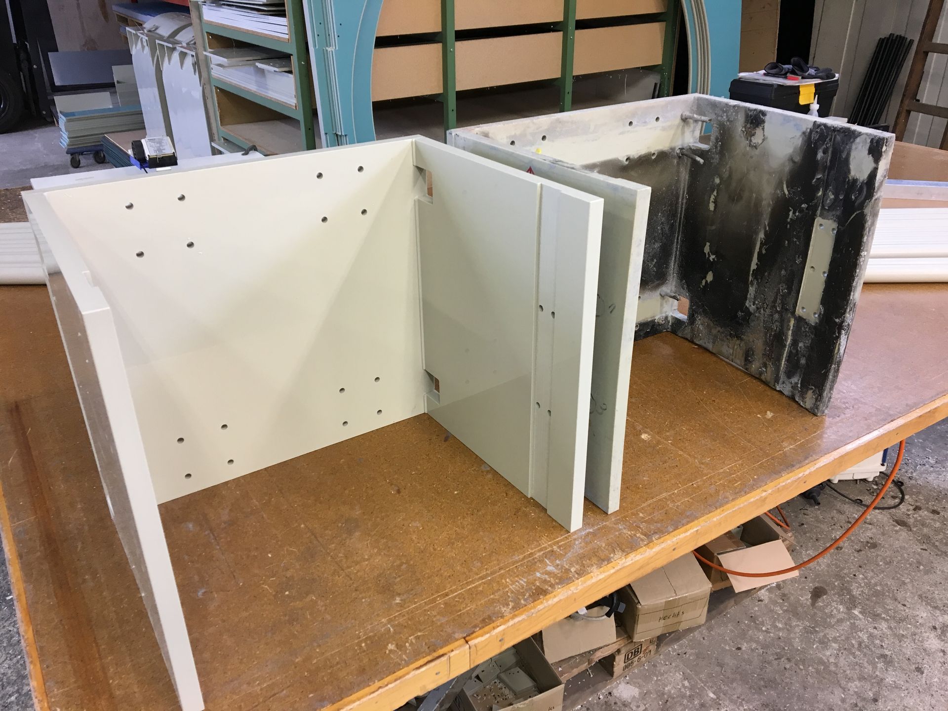 Zwei weiße Kisten stehen auf einem Holztisch.