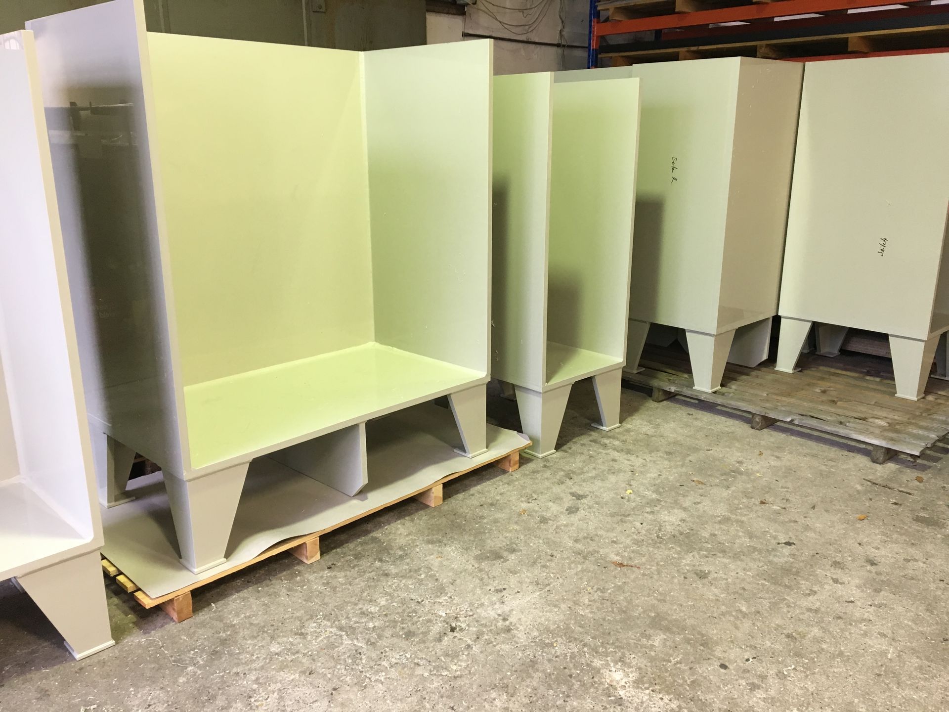 In einem Lagerhaus stehen mehrere weiße Schränke in einer Reihe.