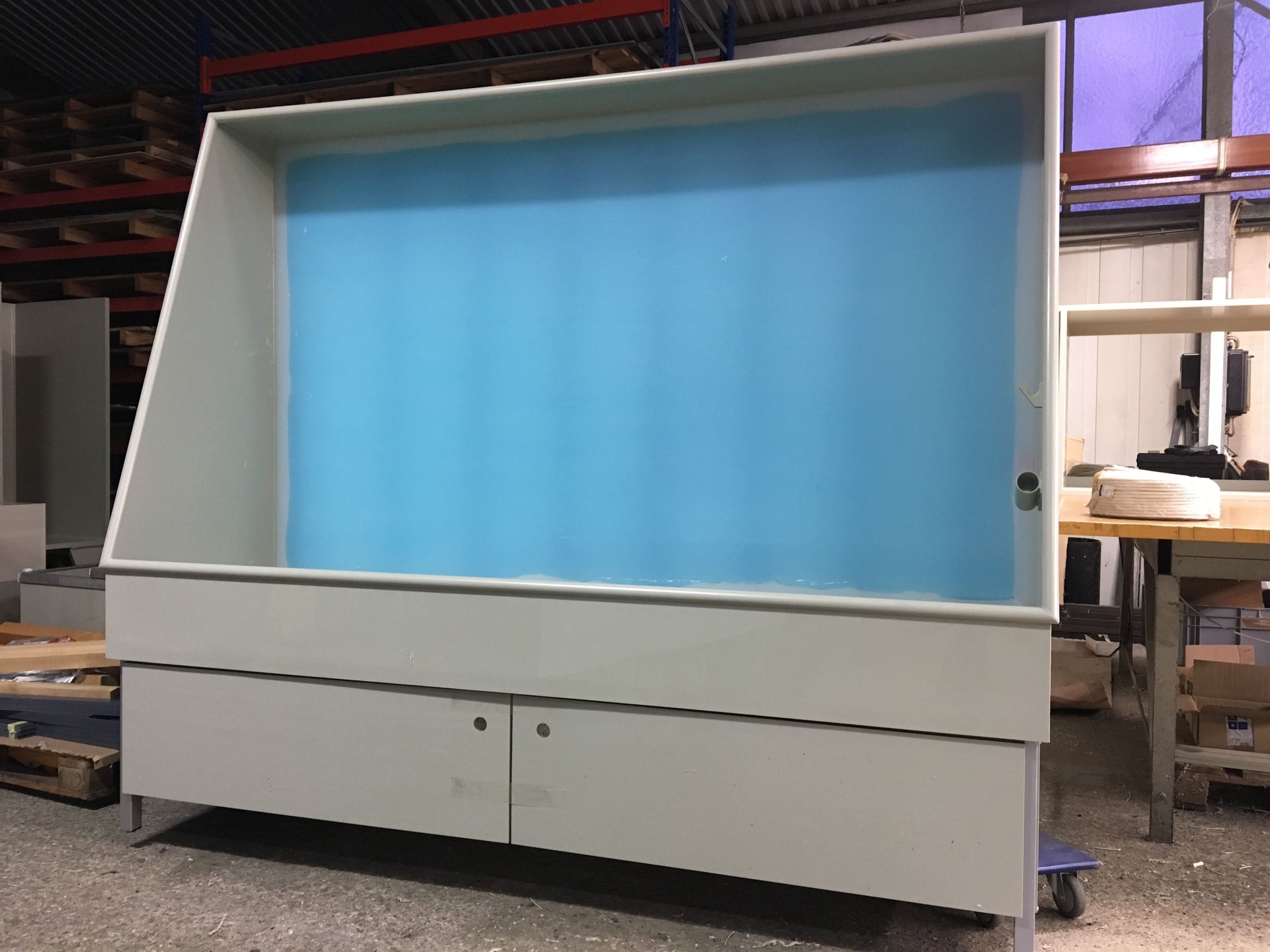 In einem Lagerhaus steht ein großer weißer Schrank mit einem blauen Vorhang.