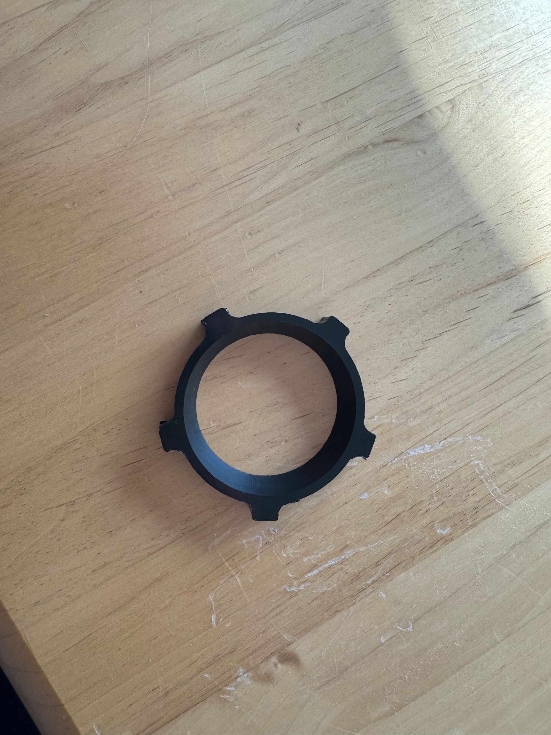 Ein schwarzer Gummiring liegt auf einem Holztisch