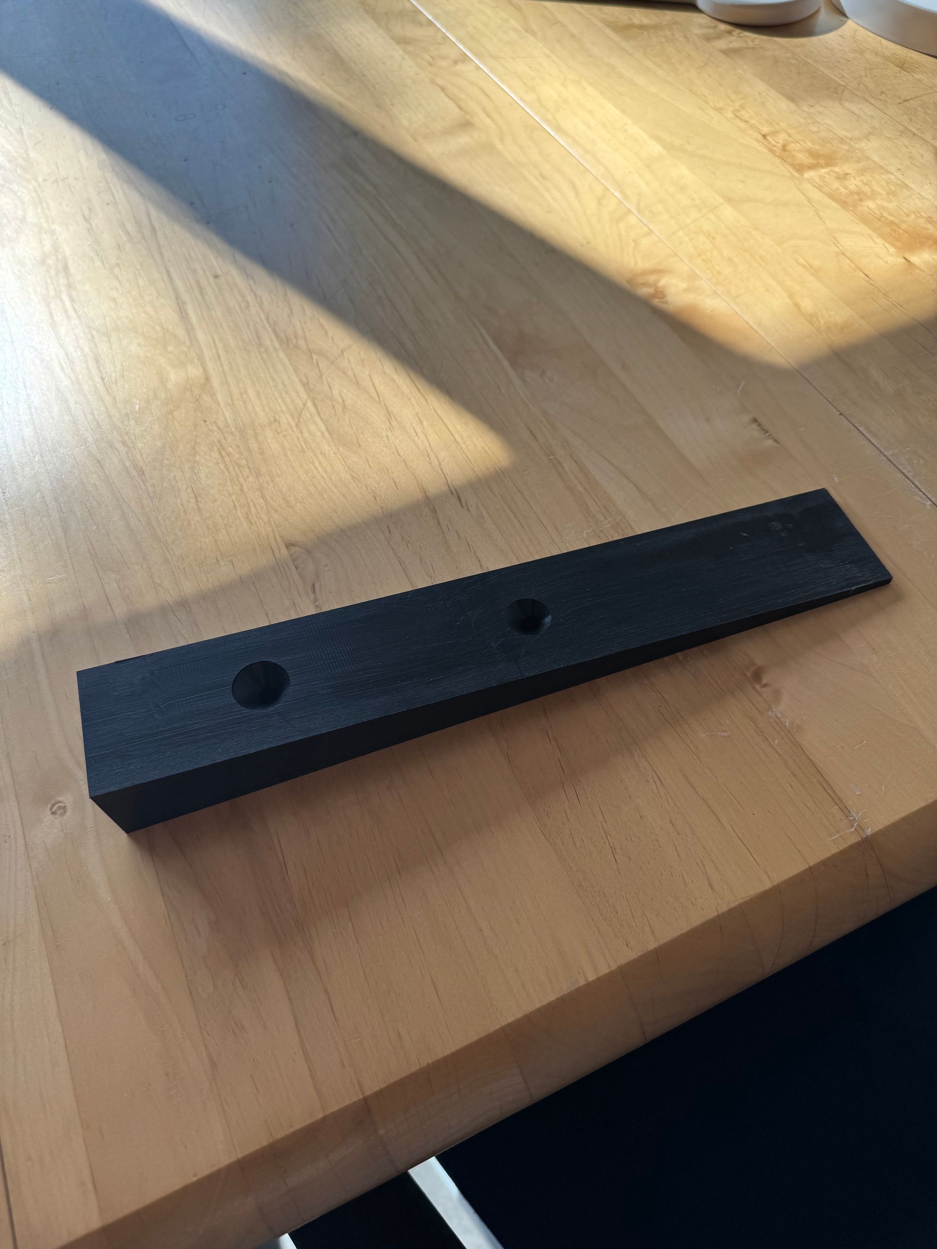 Ein Stück schwarzer Schaumstoff liegt auf einem Holztisch