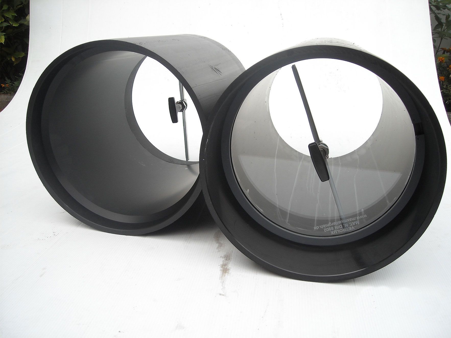 Zwei schwarze Rohre mit einem Loch in der Mitte auf einer weißen Fläche