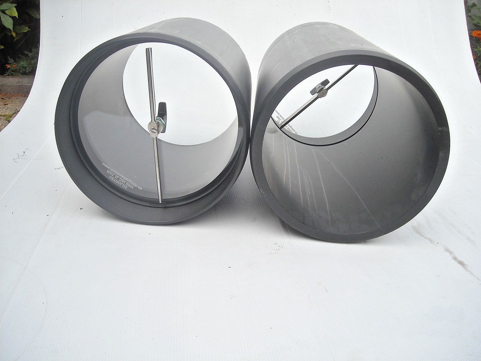 Zwei schwarze Zylinder sitzen auf einer weißen Oberfläche