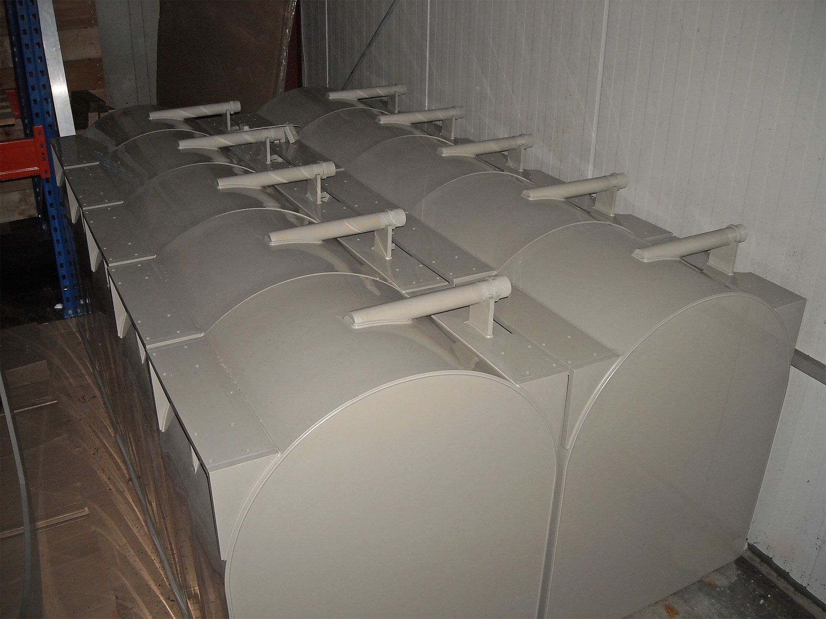 Eine Reihe weißer Behälter, die nebeneinander in einem Raum stehen.