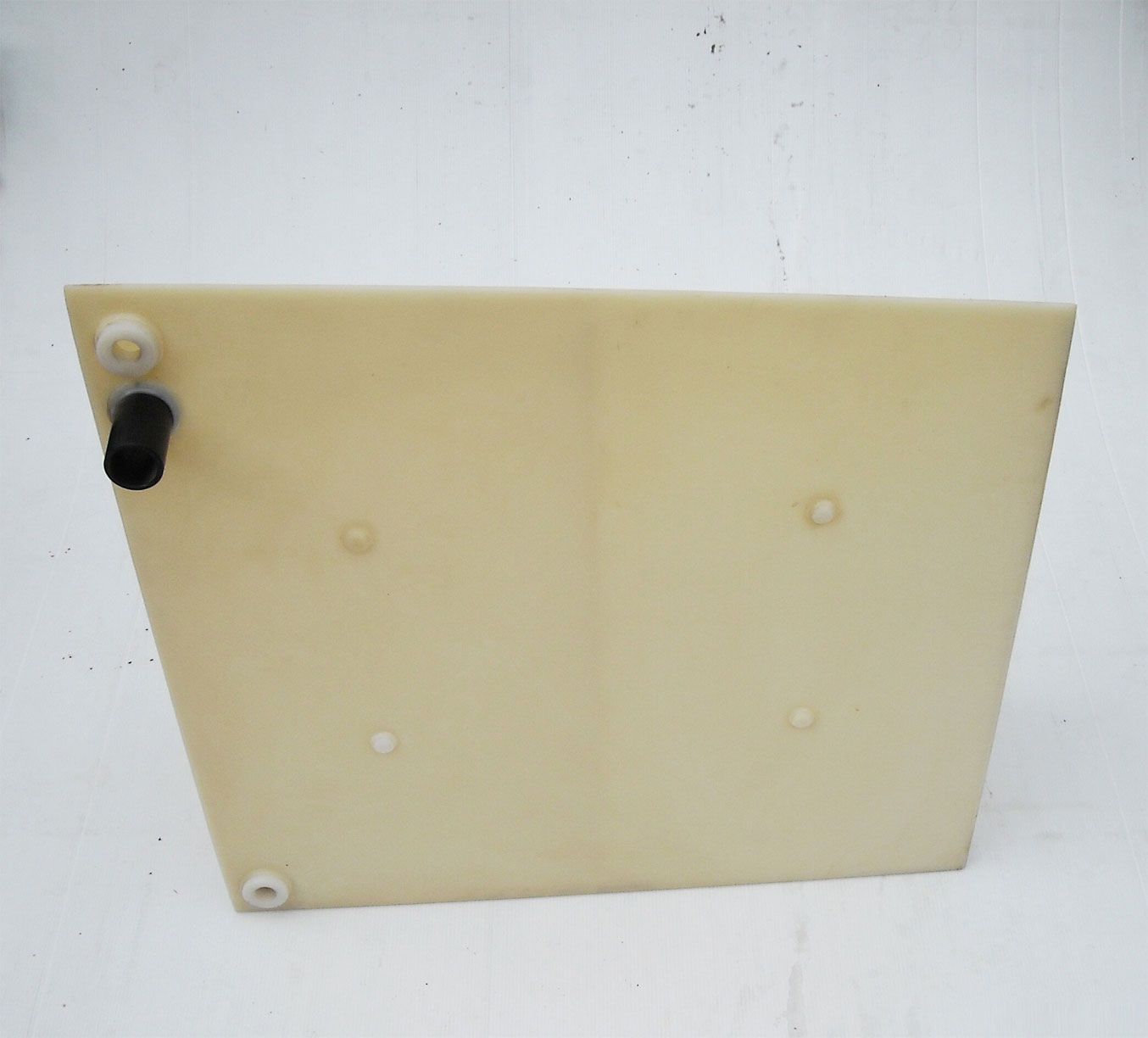 Ein Stück Plastik mit Löchern darin liegt auf einer weißen Oberfläche