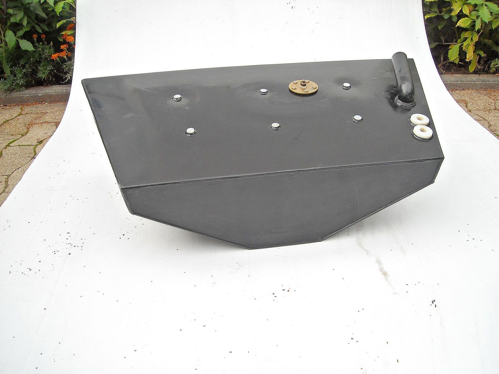 Ein schwarzer Metallgegenstand liegt auf einer weißen Oberfläche