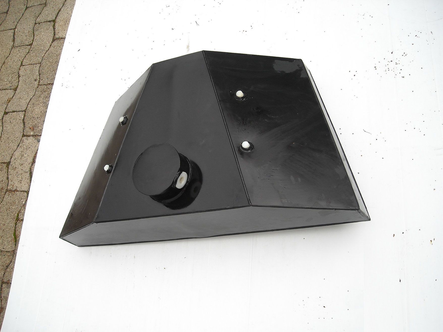 Ein schwarzer Gegenstand liegt auf einer weißen Fläche