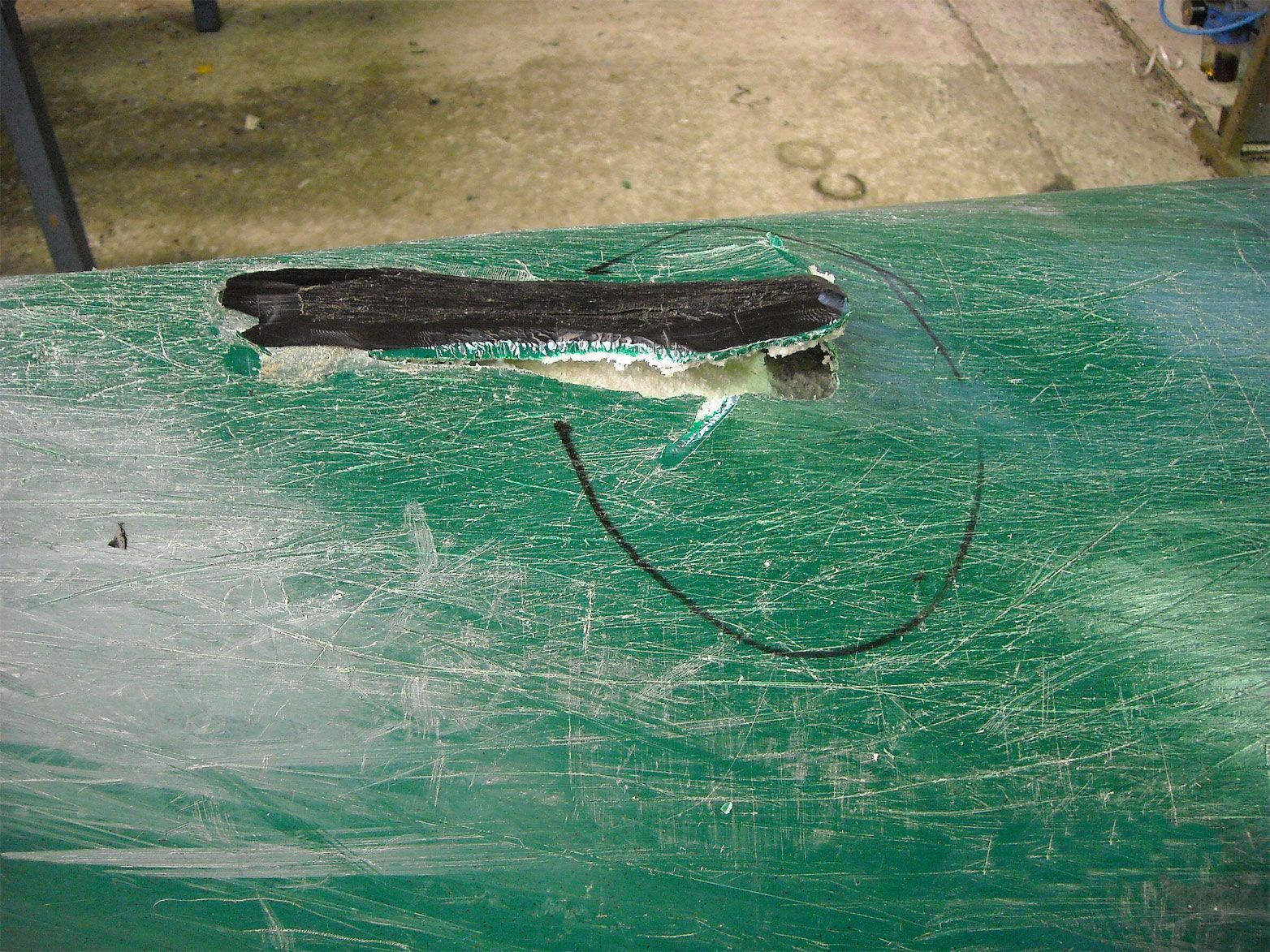 Ein Stück Holz liegt auf einer grünen Fläche.