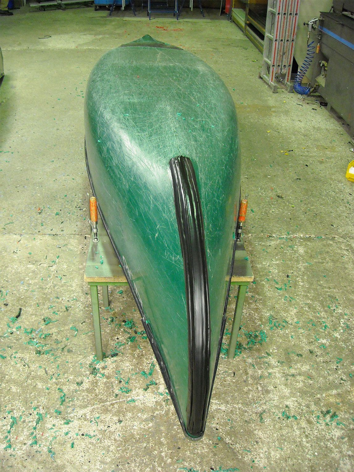 Ein grünes Kanu liegt auf einem Betonboden