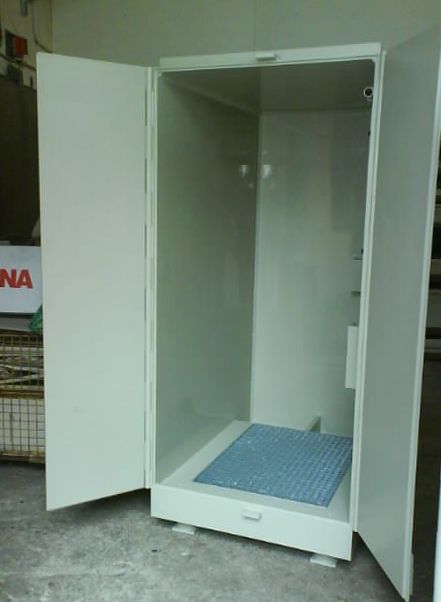 Ein weißer Schrank mit offener Tür hat eine blaue Matte auf dem Boden