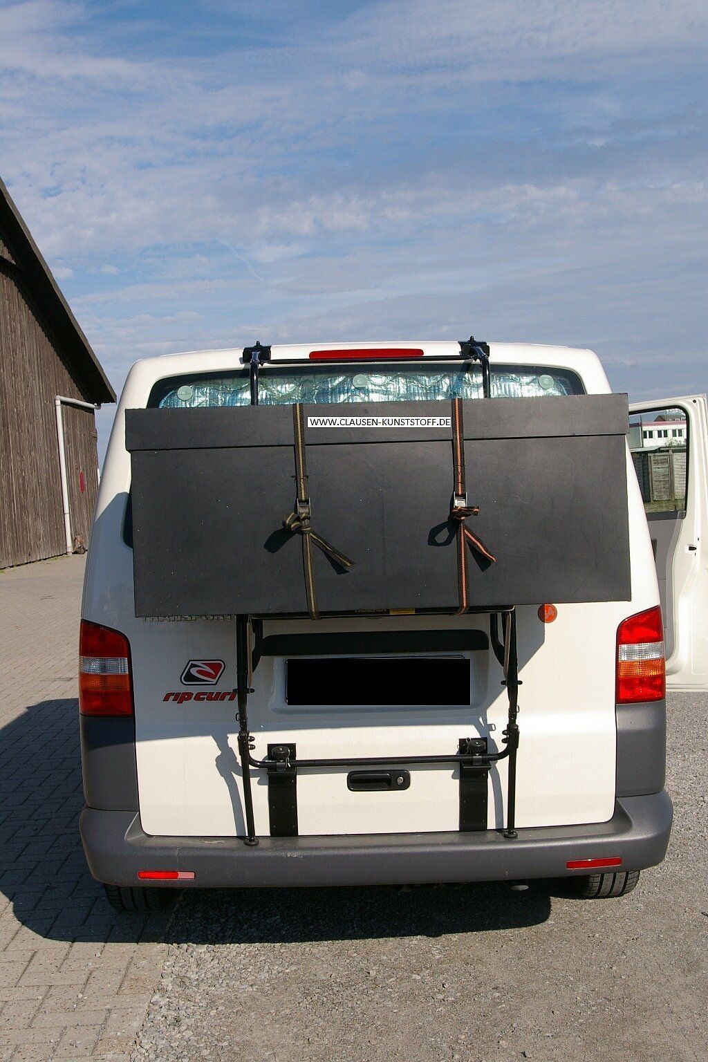 Ein weißer Lieferwagen mit einer schwarzen Box an der Rückseite