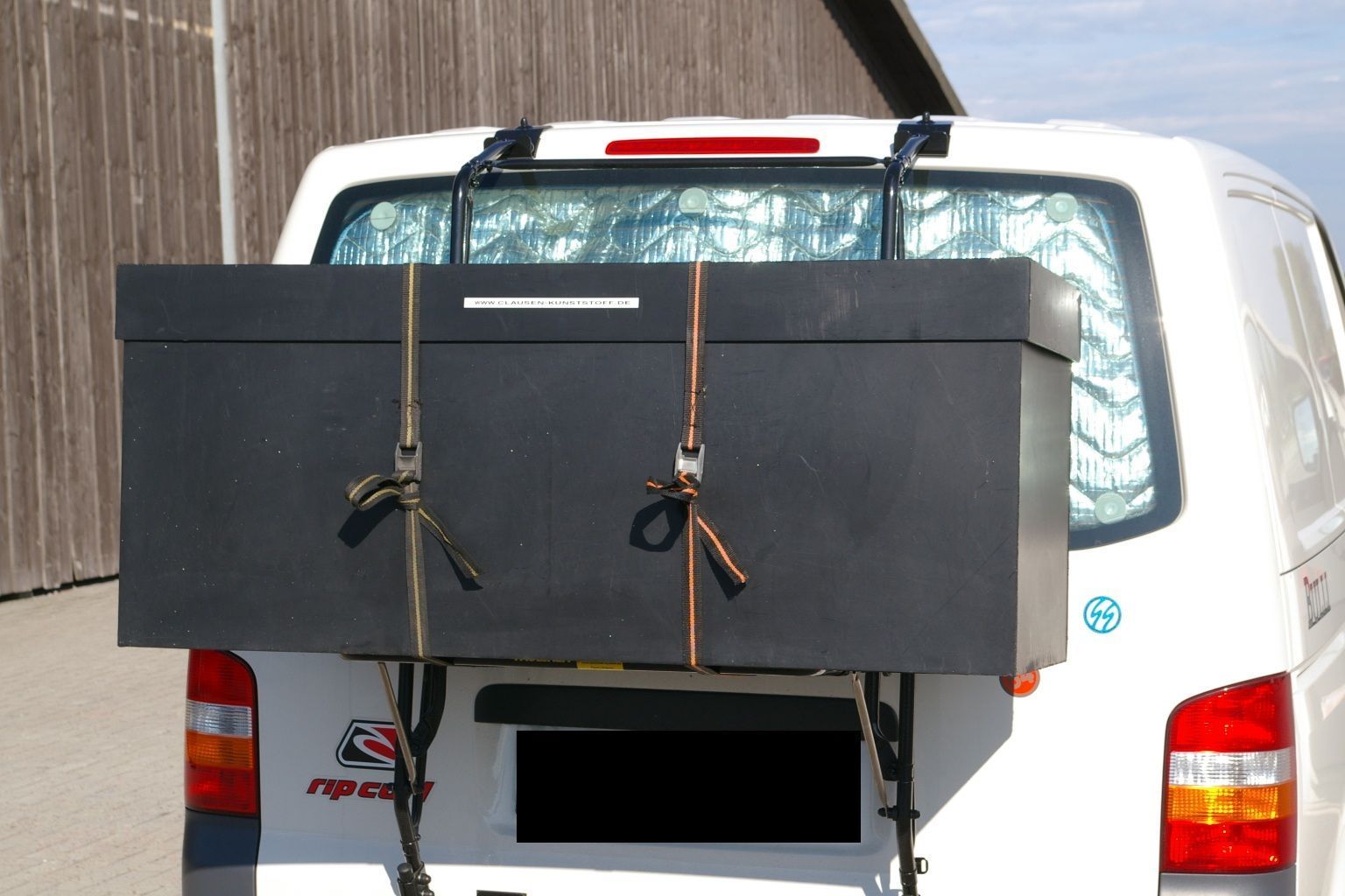 Eine große schwarze Box ist an der Rückseite eines weißen Lieferwagens befestigt