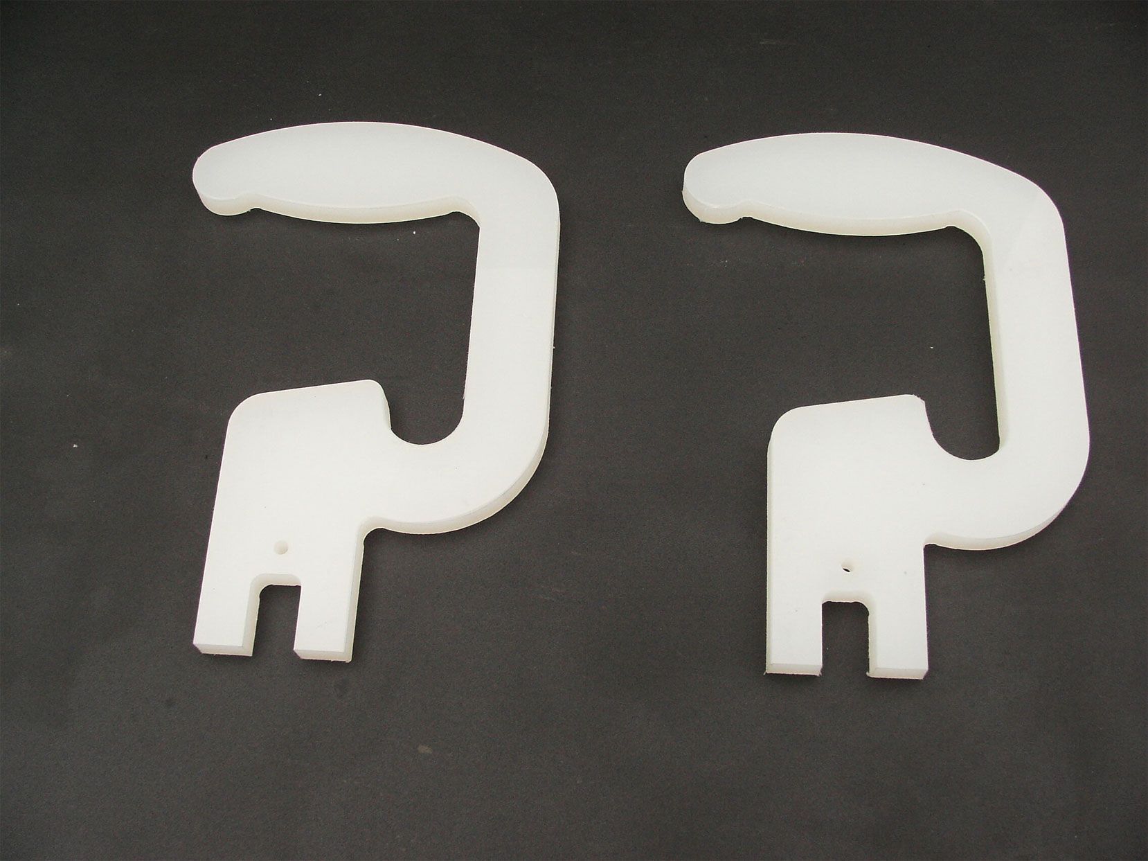 Ein Paar weiße Kunststoffgriffe auf schwarzem Untergrund