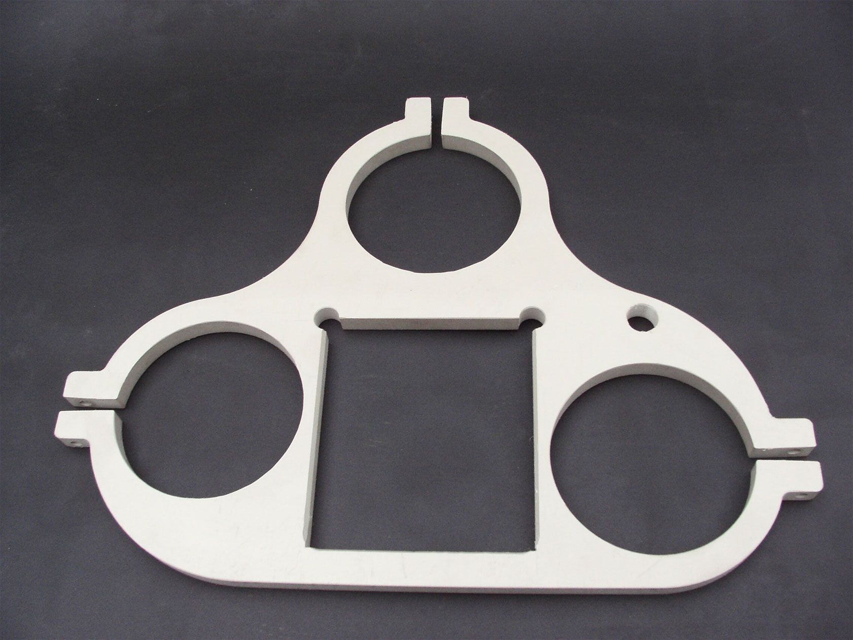 Ein weißes Objekt mit Löchern darin liegt auf einer schwarzen Oberfläche