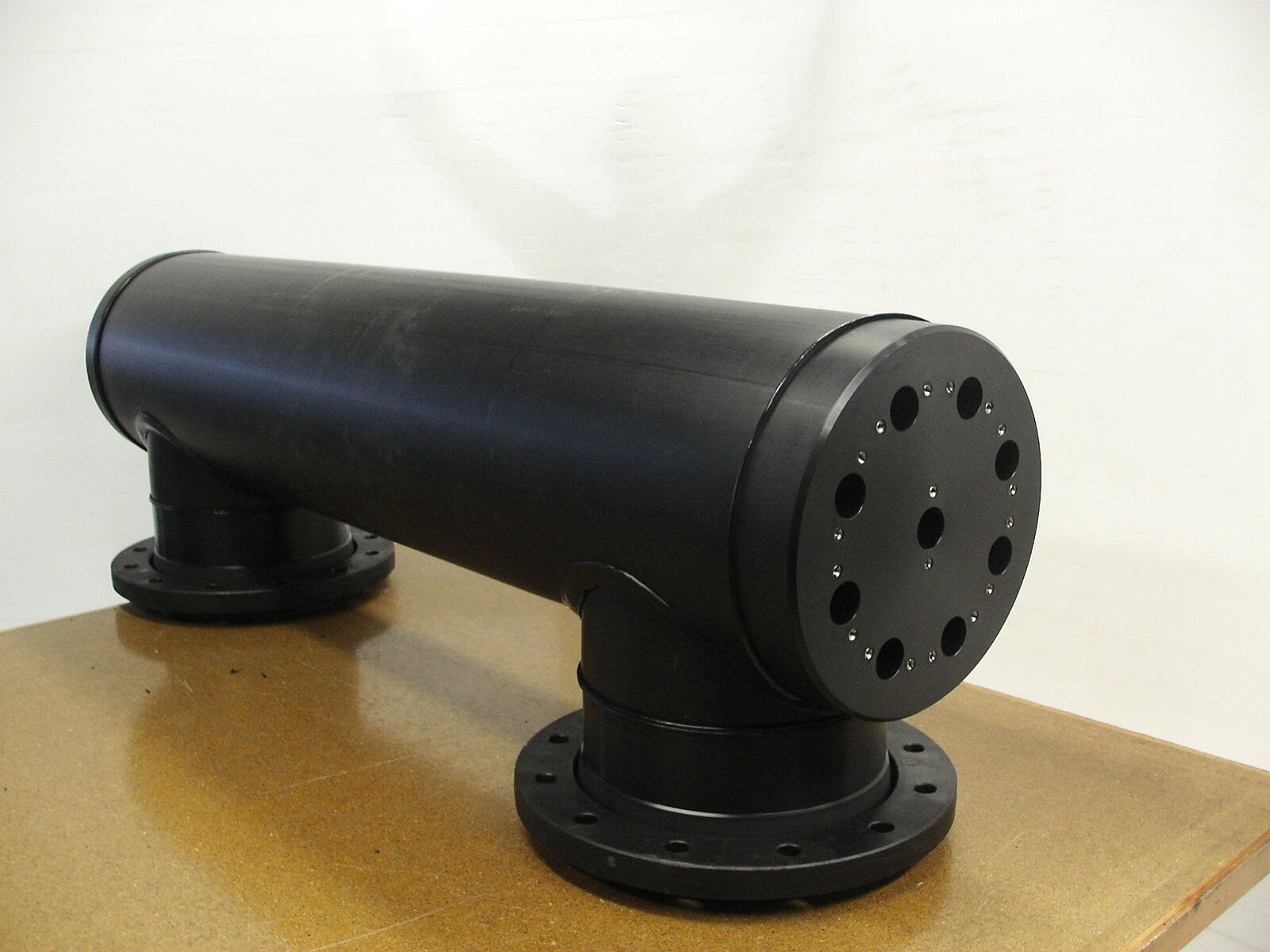 Ein schwarzes Rohr mit Löchern darin liegt auf einem Tisch