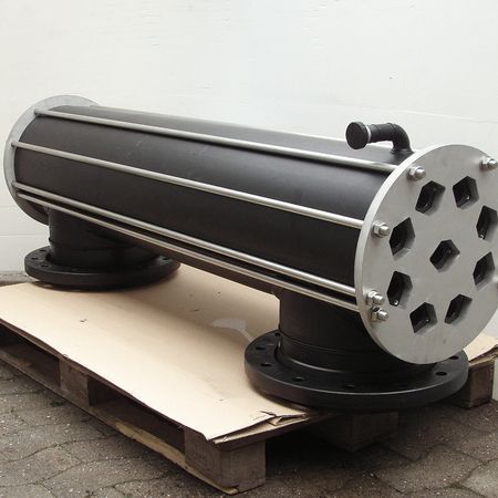 Ein großes schwarzes Rohr liegt auf einer Papppalette