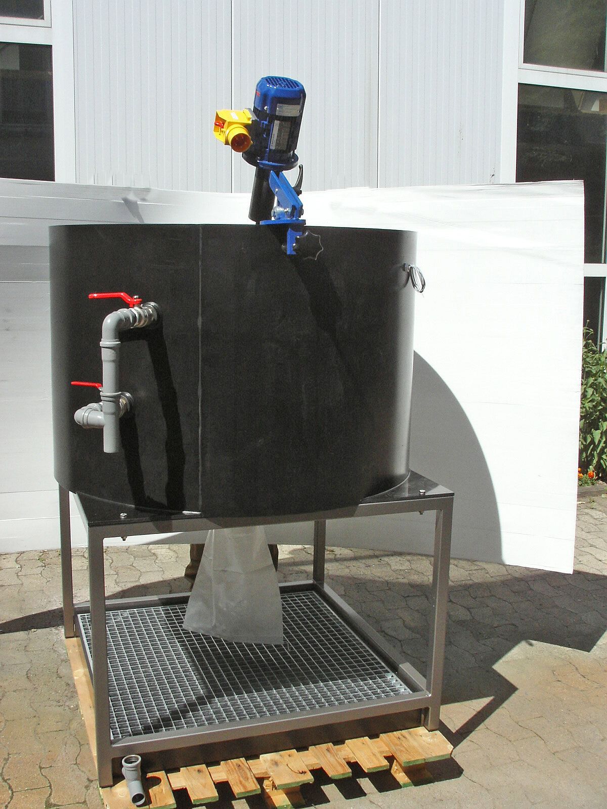 Ein großer schwarzer Container mit einem daran befestigten blauen Motor