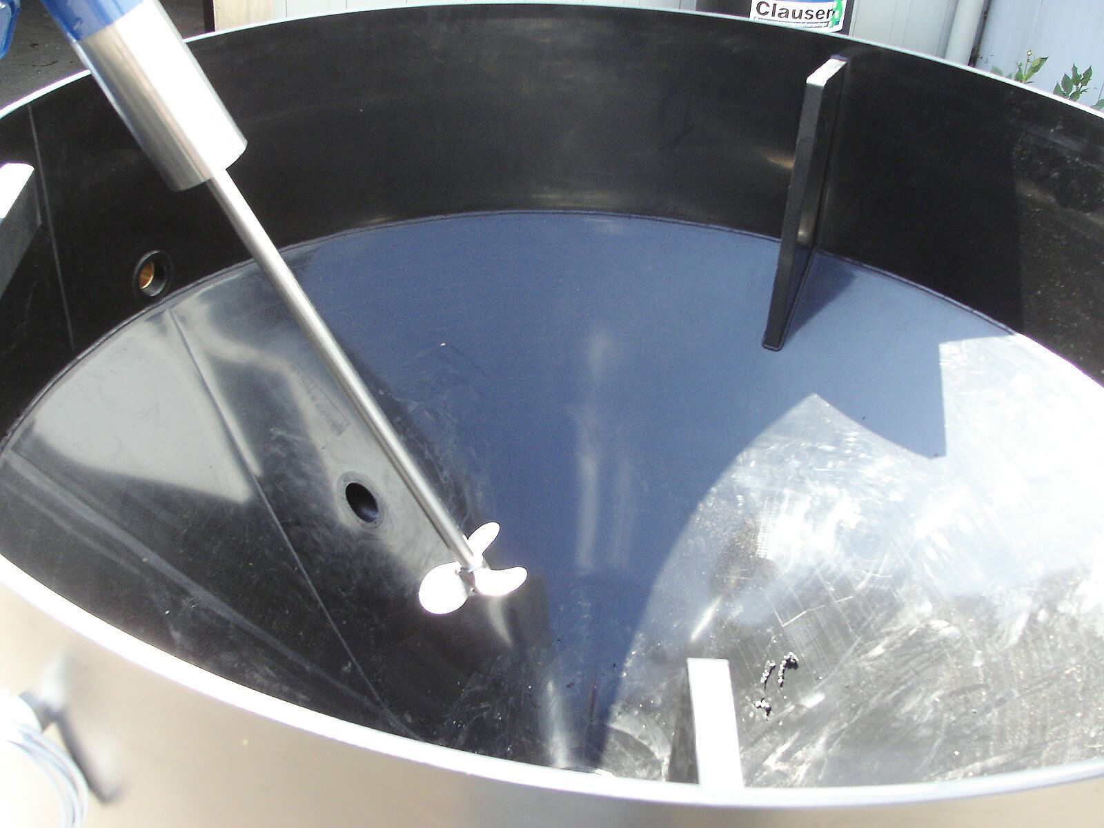 Ein großer Metallbehälter mit einer blauen Flüssigkeit darin