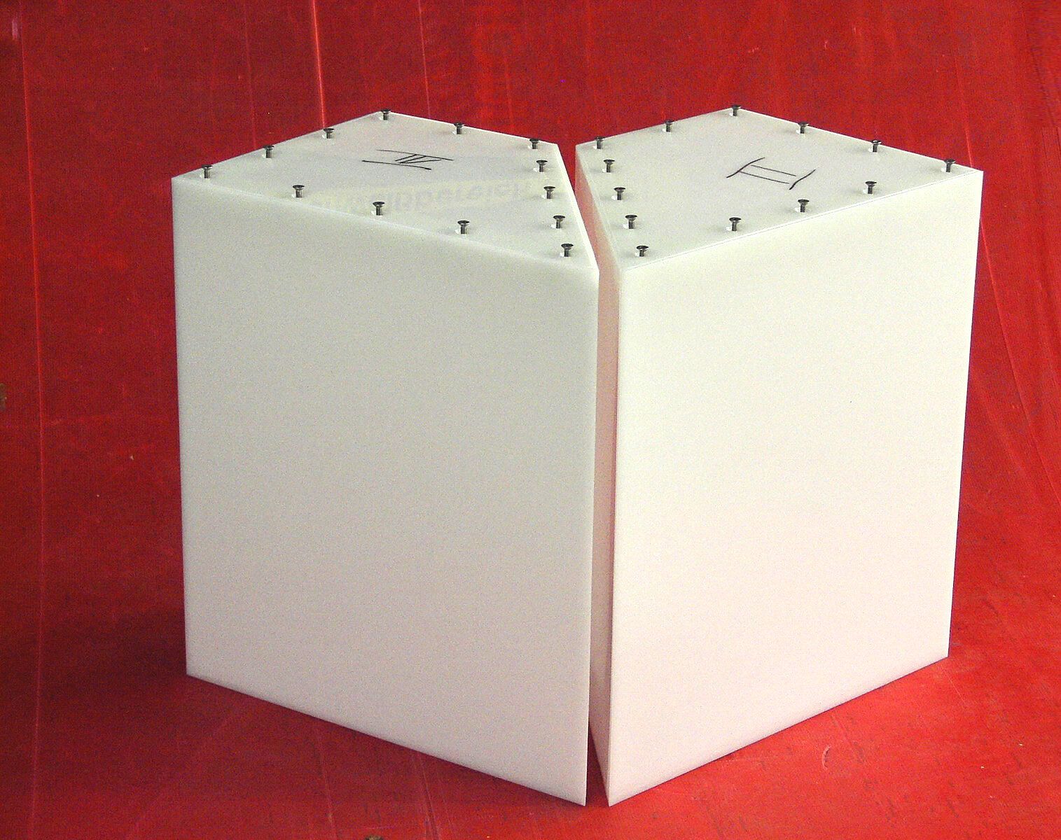 Zwei Stücke Styropor liegen auf einer roten Oberfläche