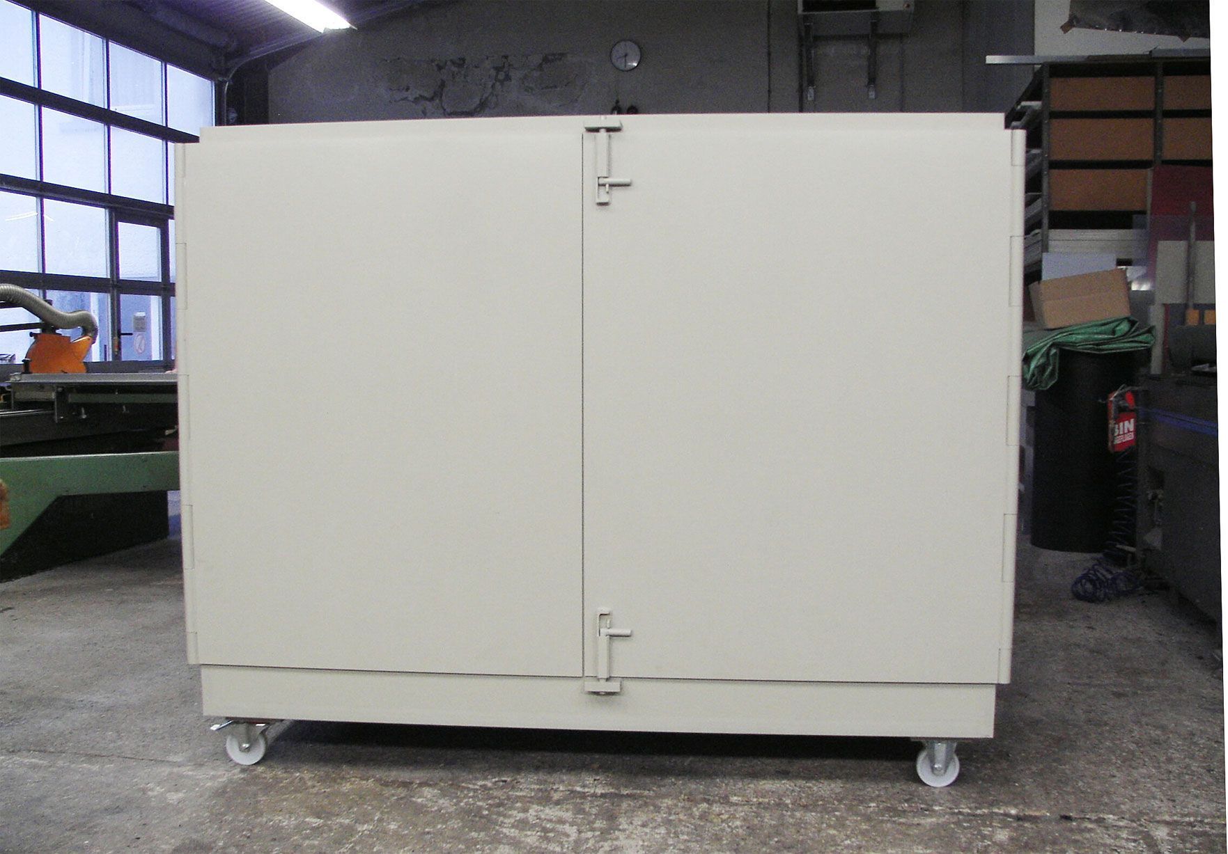 Ein weißer Schrank mit Rädern steht in einem Lager