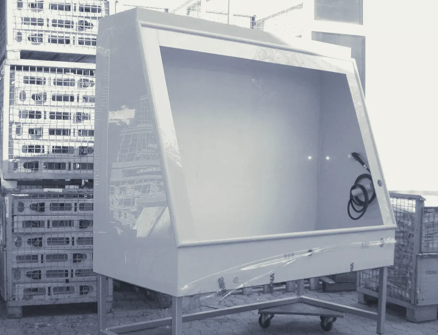Ein Schwarzweißfoto einer großen weißen Kiste auf einem Wagen.