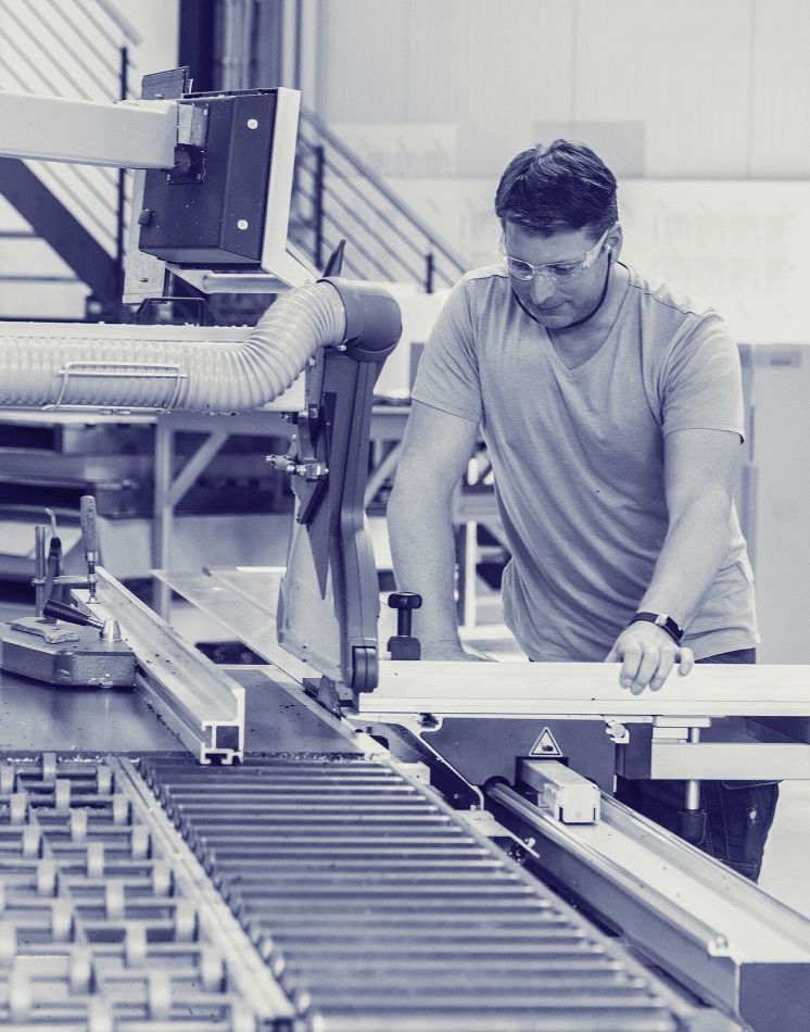 Ein Mann arbeitet in einer Fabrik an einer Maschine.