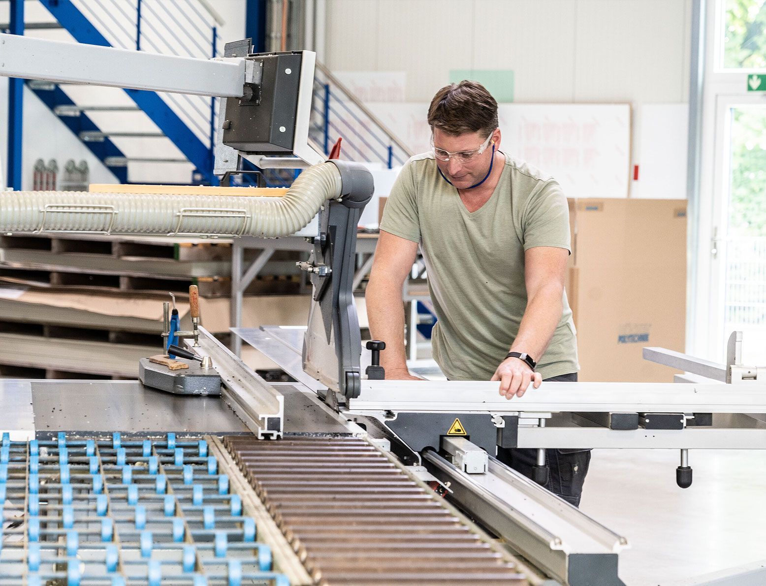 Ein Mann arbeitet in einer Fabrik an einer Maschine.