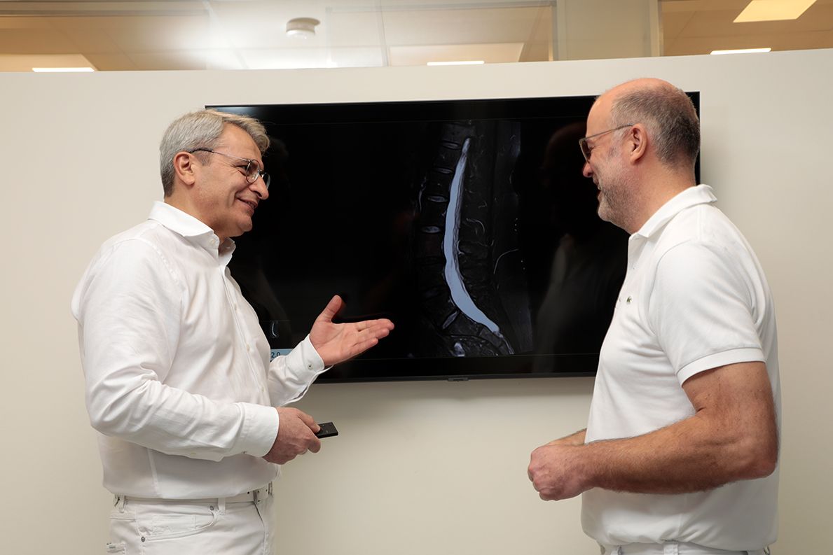 Dr. Altunok bespricht ein Röntgenbild einer Wirbelsäule mit Dr. Borowski