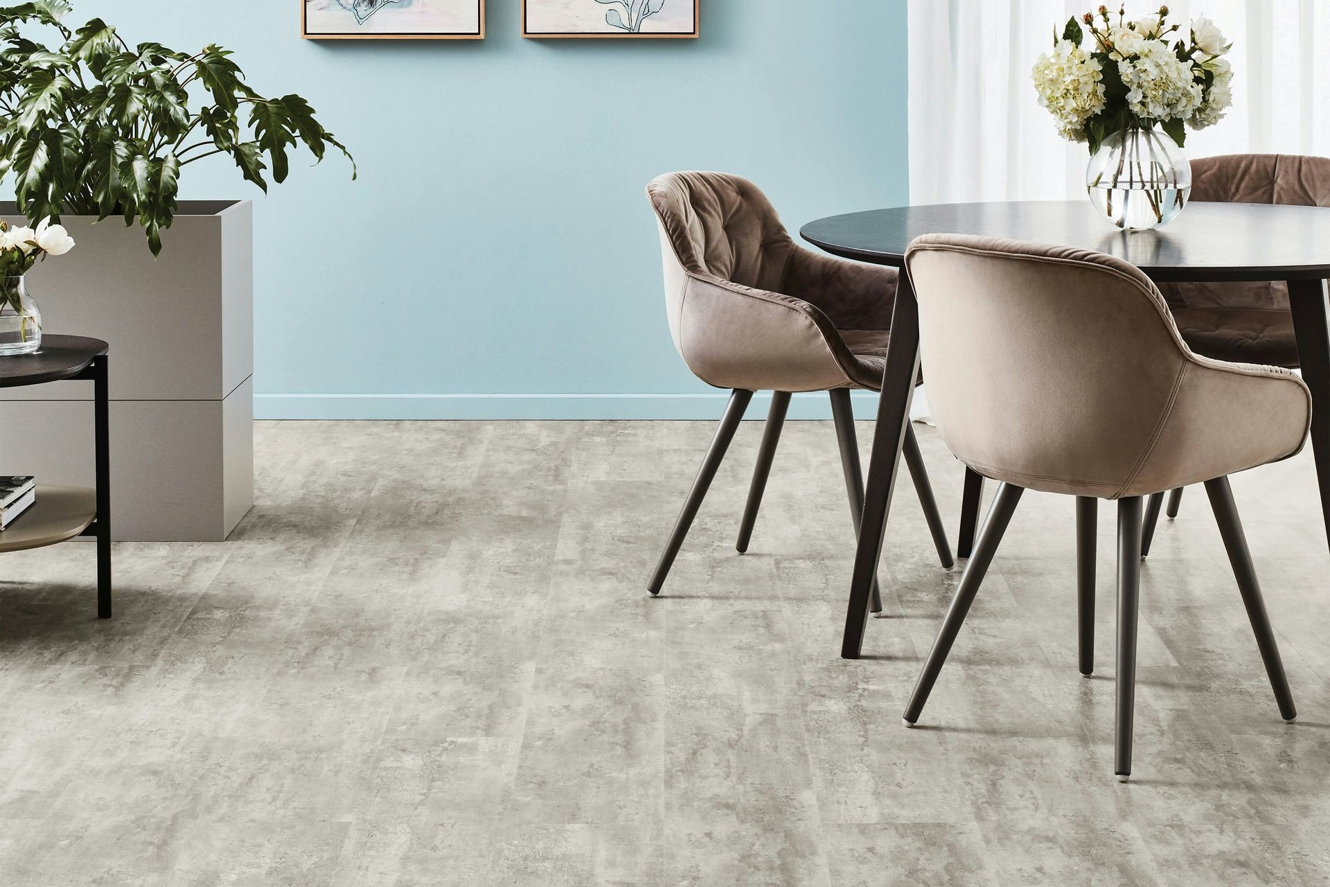 Habitación vacía con azulejos, grandes ventanales y una columna blanca que refleja la luz en el suelo.