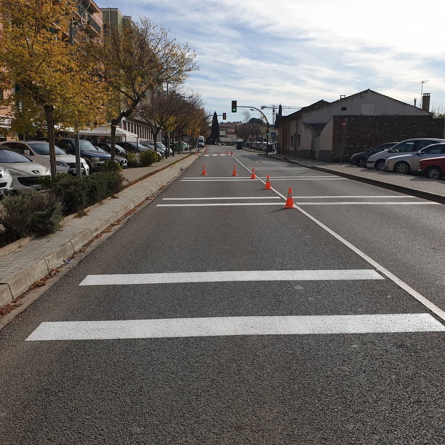 Una calle con un paso de peatones y conos naranjas a los lados