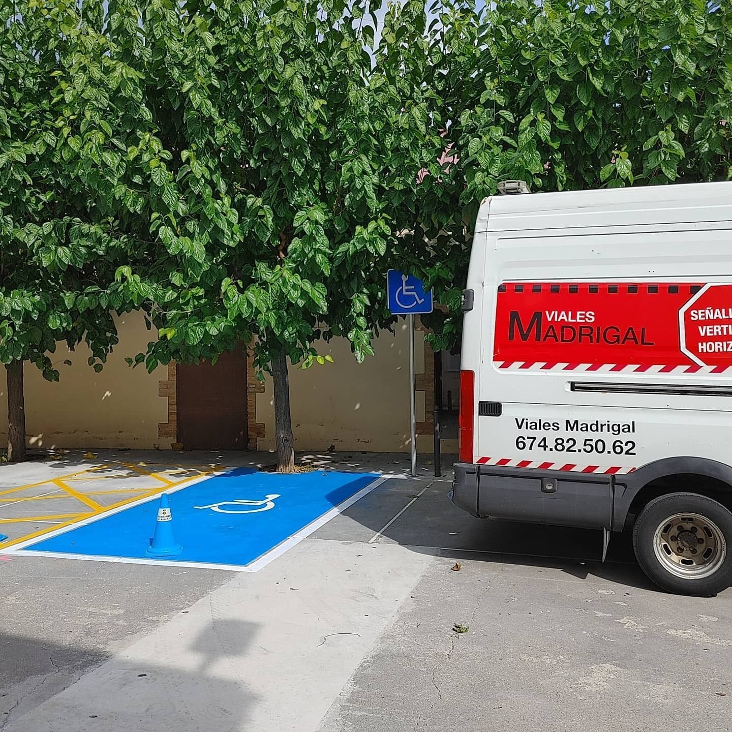 Una camioneta blanca está estacionada en un lugar de estacionamiento para discapacitados.