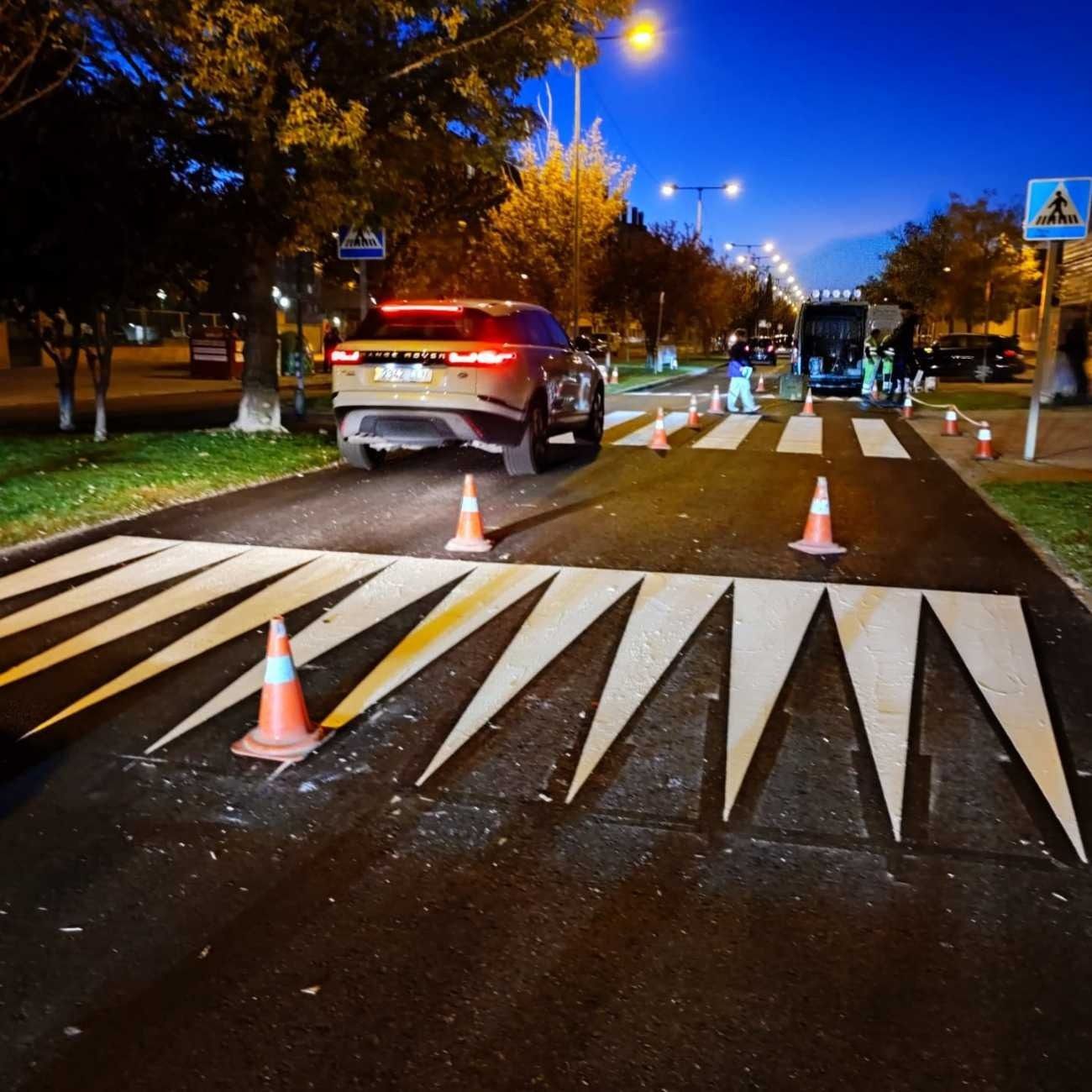 Un coche circula por un paso de cebra por la noche.