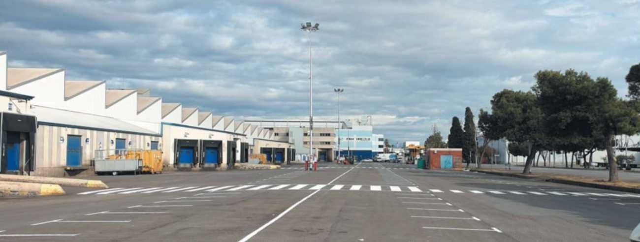 Un estacionamiento con muchos edificios al fondo.