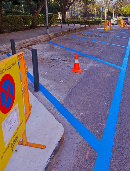 Un estacionamiento con líneas azules y una señal de no estacionar.