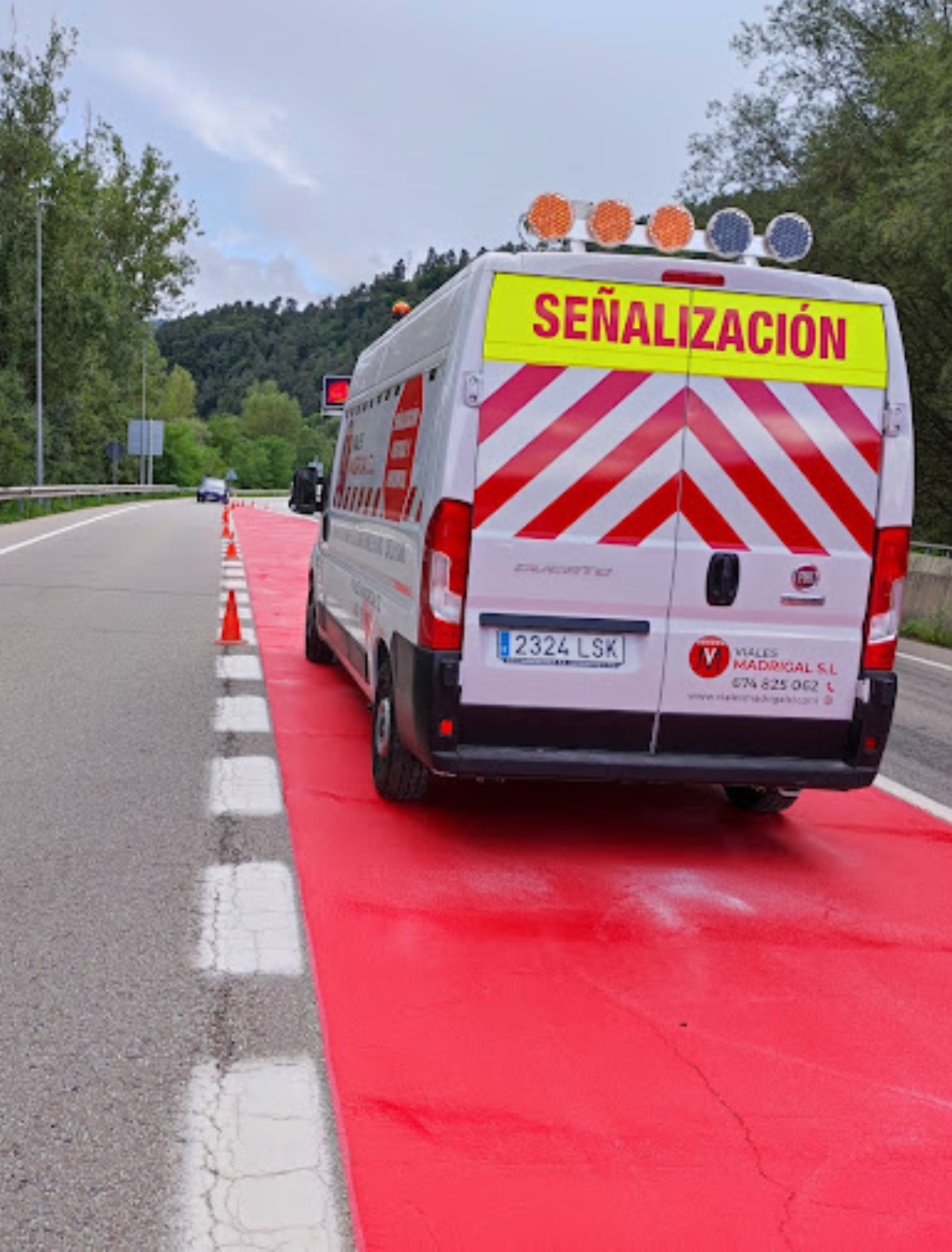 Una furgoneta de señalización está estacionada al costado de la carretera