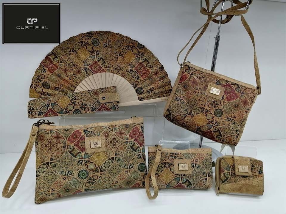 Un abanico, un bolso, una billetera y un clutch se exhiben en un estante.