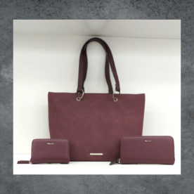 Un bolso morado y dos carteras sobre una mesa.