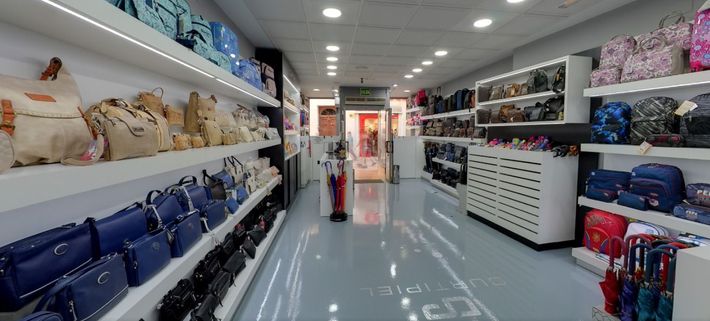 Una tienda llena de muchos bolsos y paraguas.