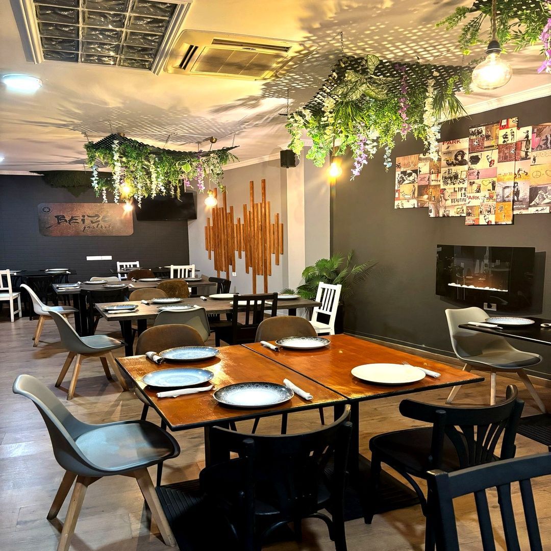 Un restaurante con mesas y sillas y platos en ellas.