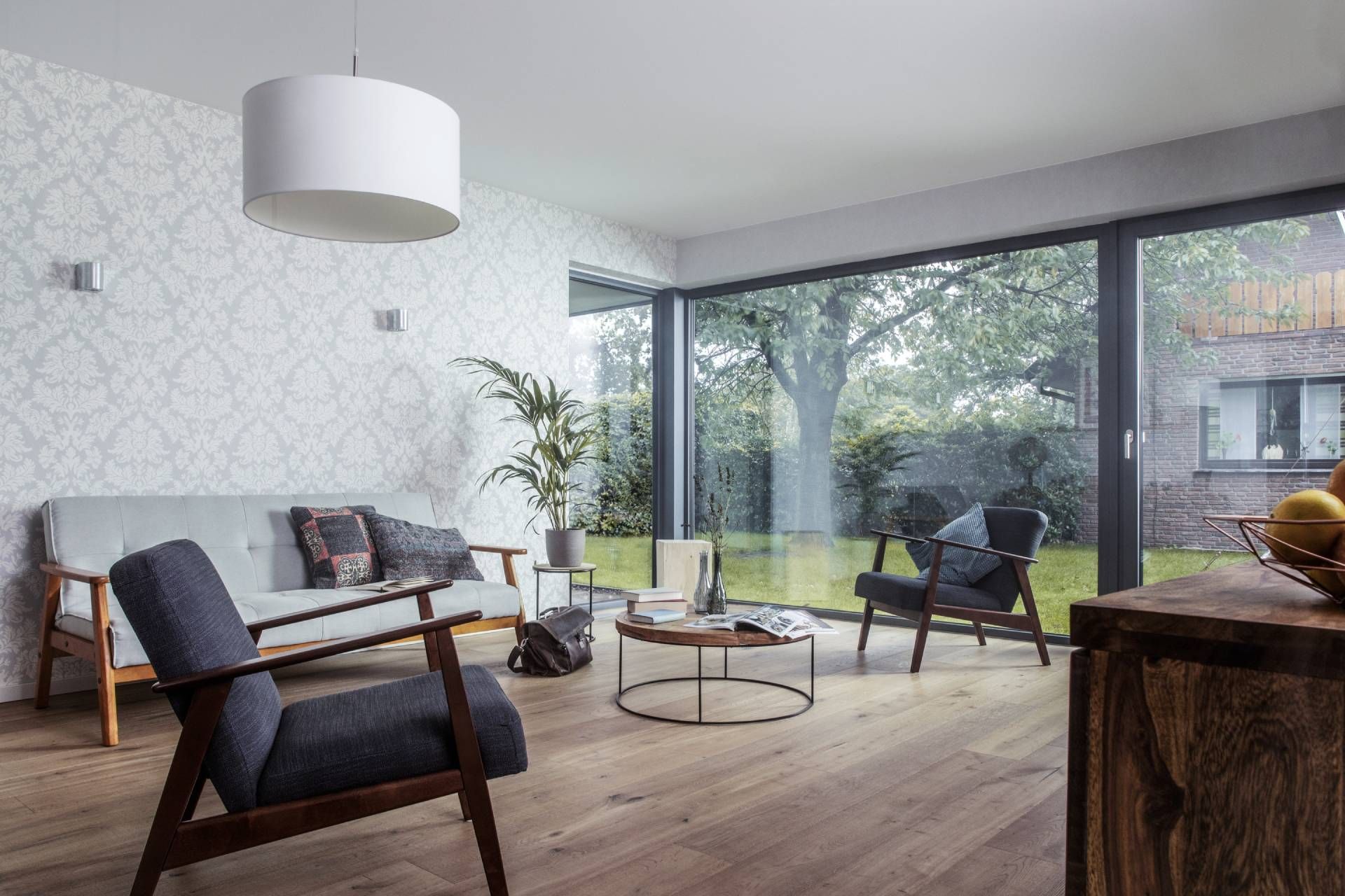 Modernes Wohnzimmer mit großen bodentiefen Fenstern