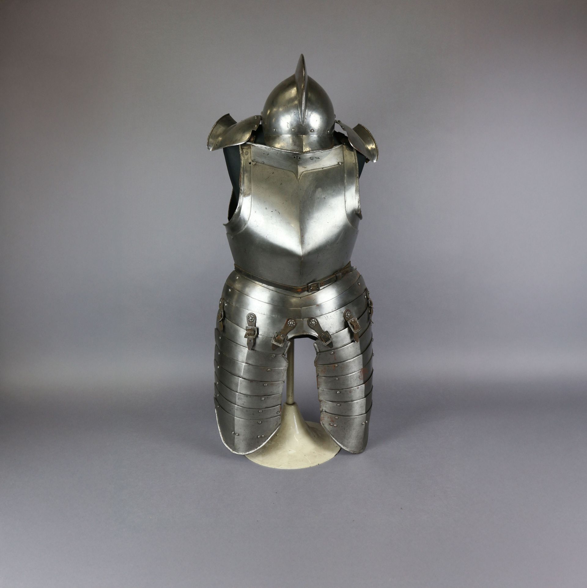 Armure médiévale en acier sur support, comprenant un casque, un plastron et une protection des jambes