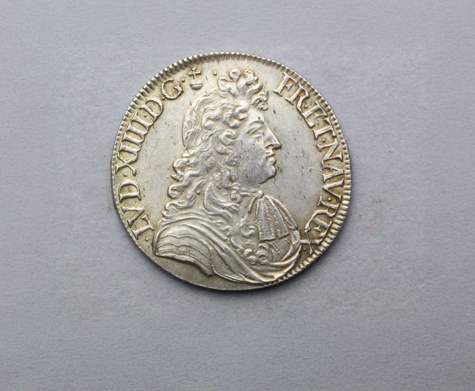 Pièce d'argent avec un profil d'un homme portant une couronne et des vêtements détaillés